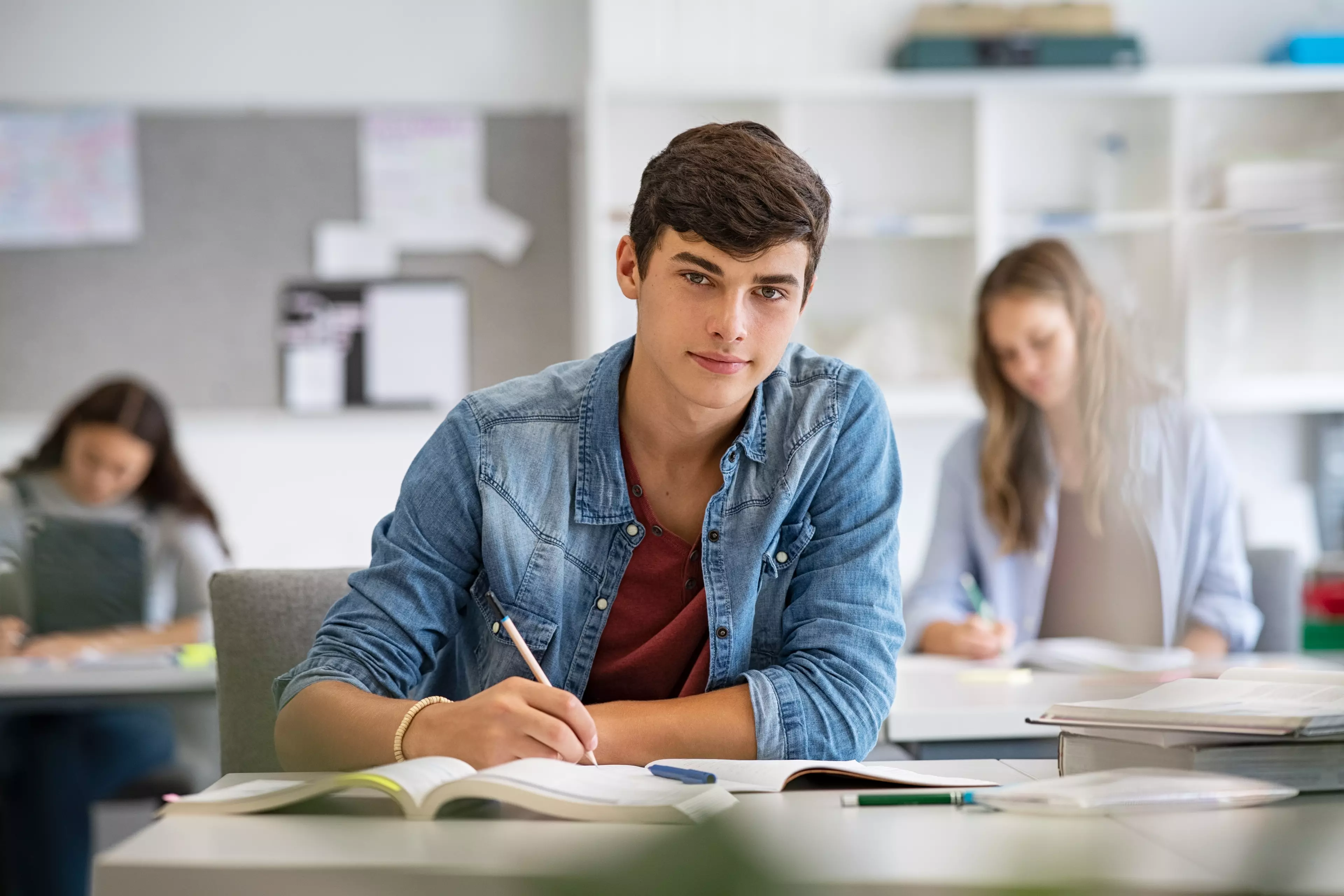 Young male student sitting behind a test, taking a test