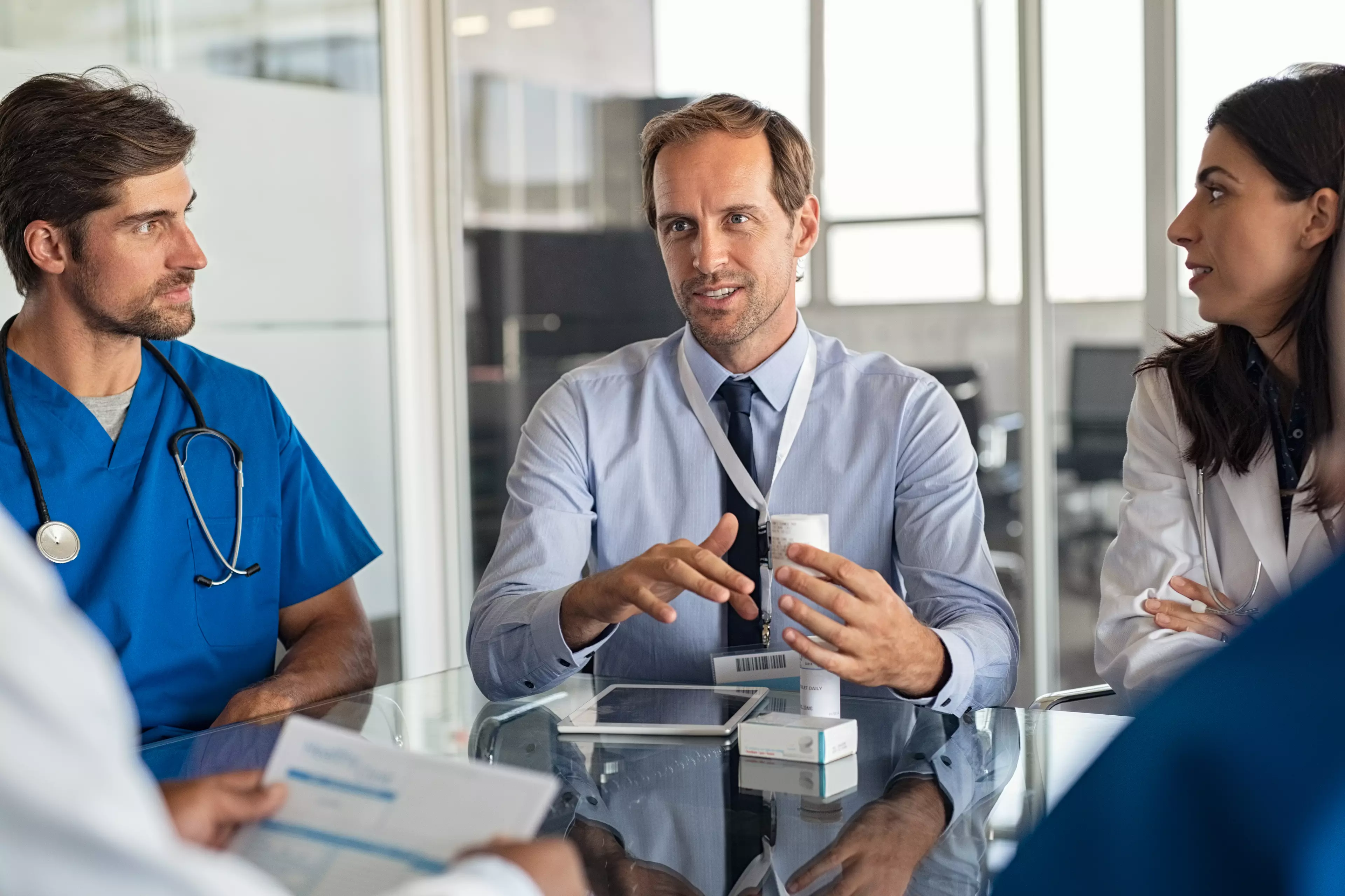  Doctors sitting at a table, having a conversation.