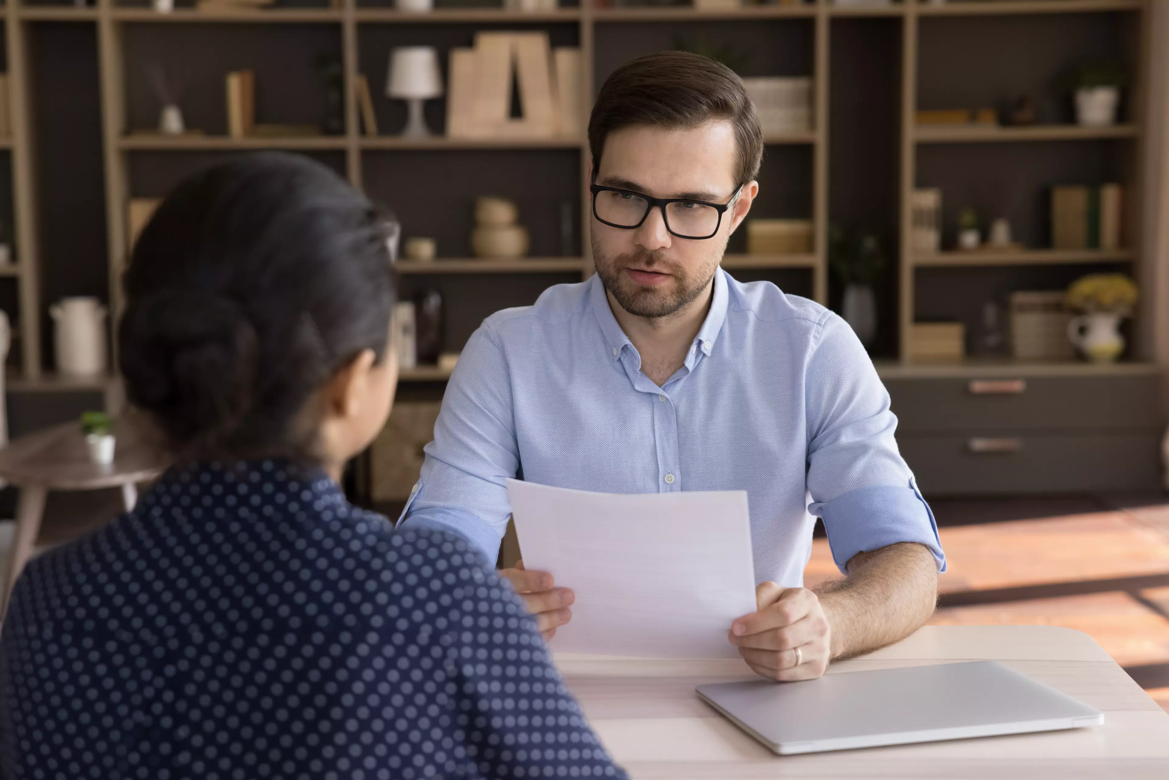 A man and a woman in an office, during a job interview.