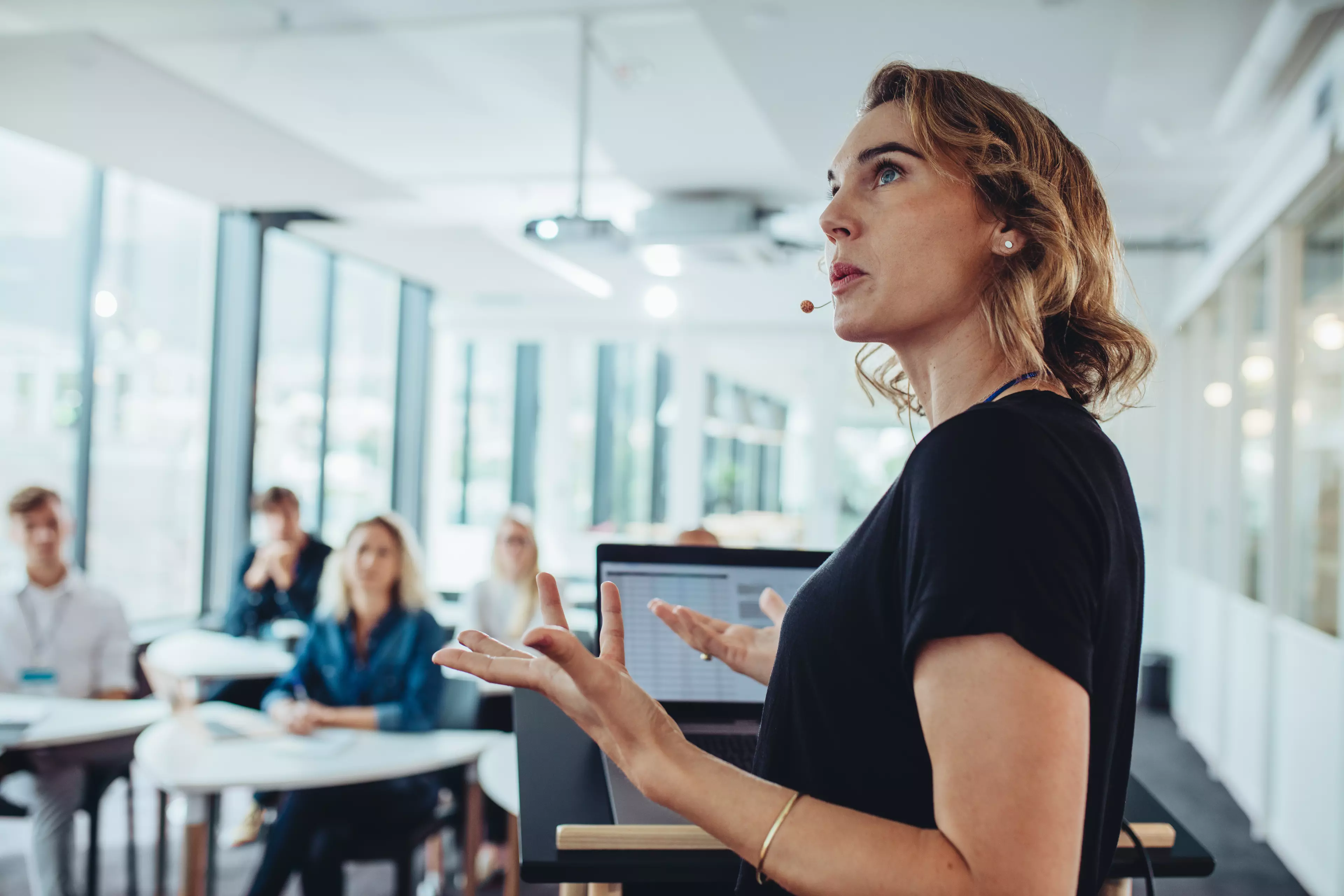 Young woman speaking to an audience in the office.